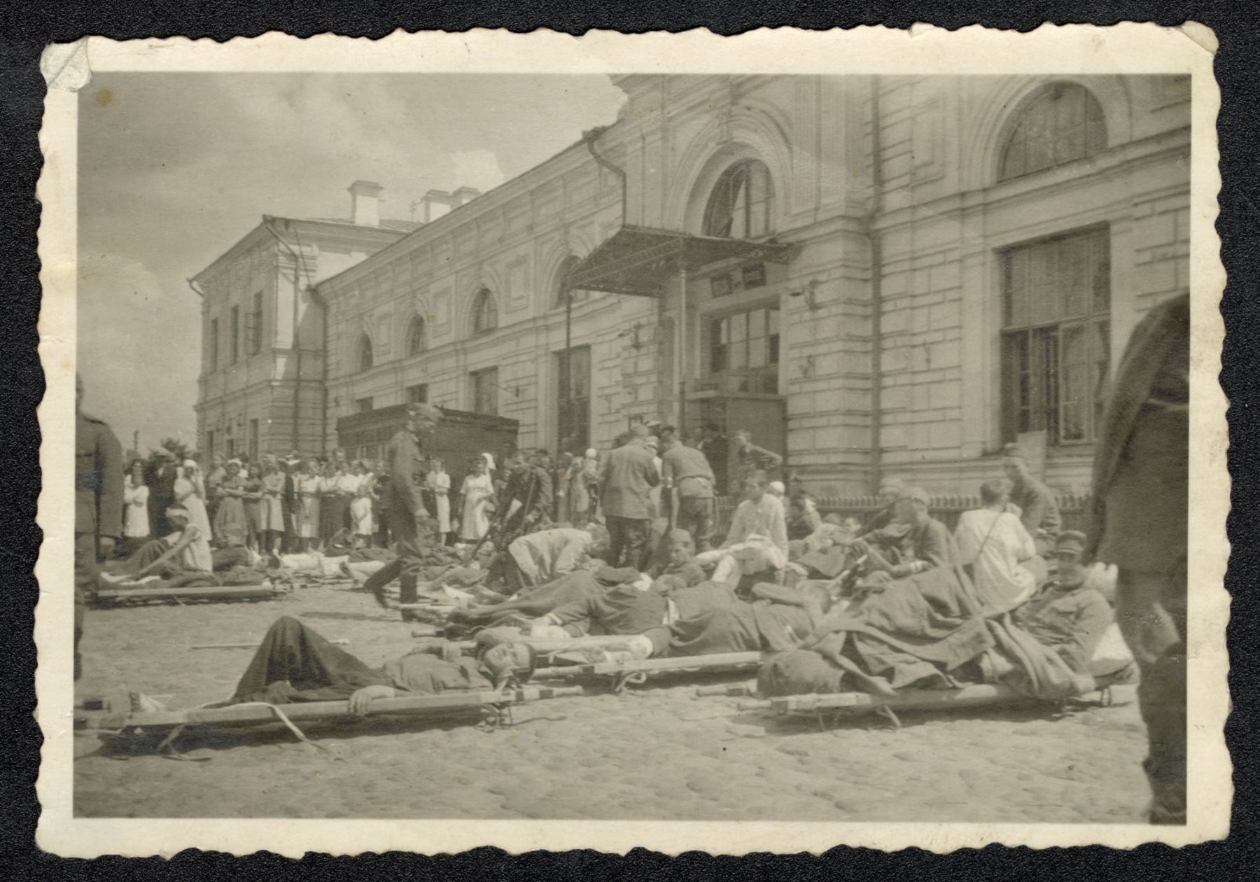 People lying on stretchers in front of the building