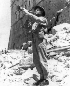 Żołnierz stoi na gruzach, grając na trąbce
