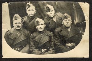 Na zdjęciu widać pięciu żołnierzy w płaszczach i furażerkach na głowach