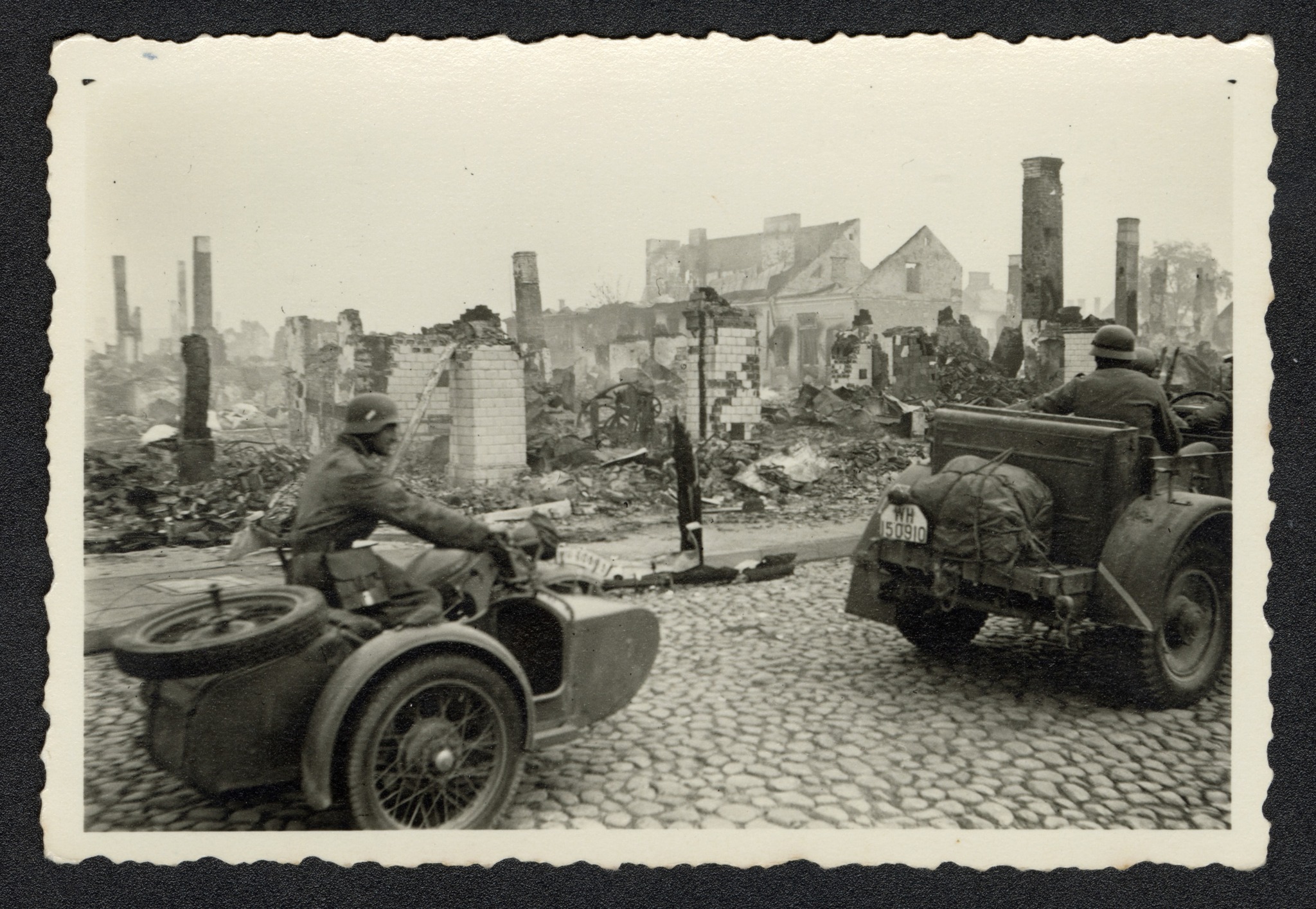 Zdjęcie żołnierzy niemieckich z okresu II wojny światowej na motocyklu wśrod ruin budynków