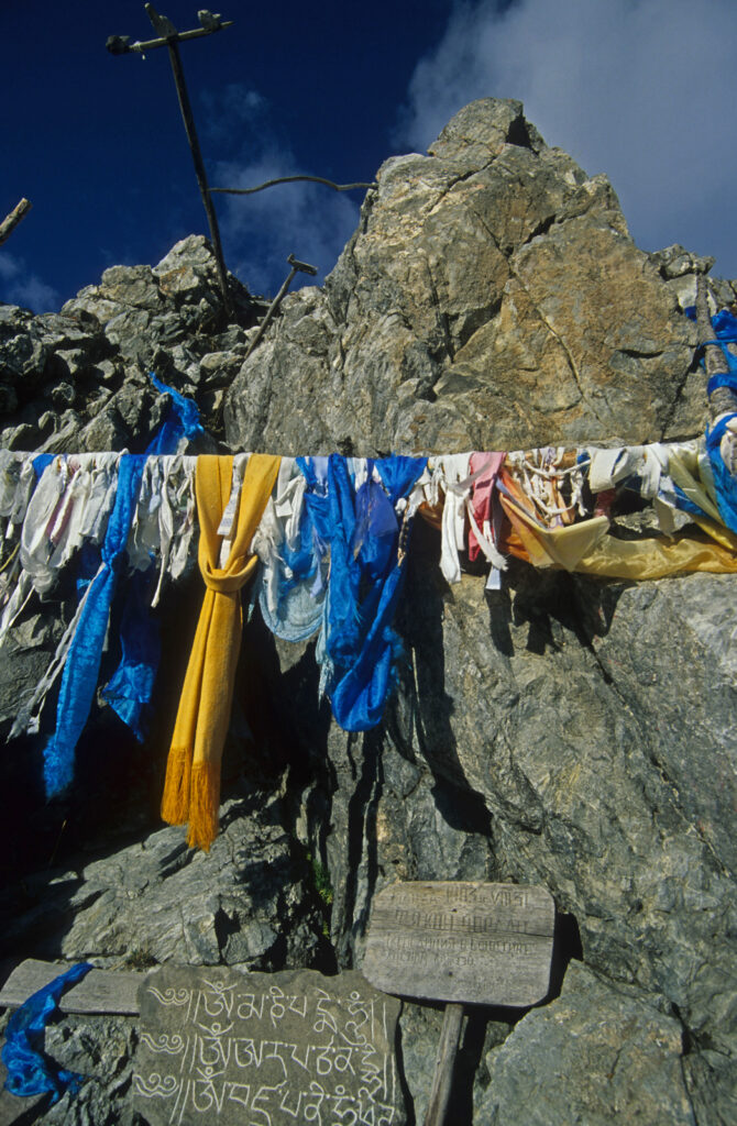 Na zdjęciu widać kolorowe szmaty wiszące na sznurku przy skale