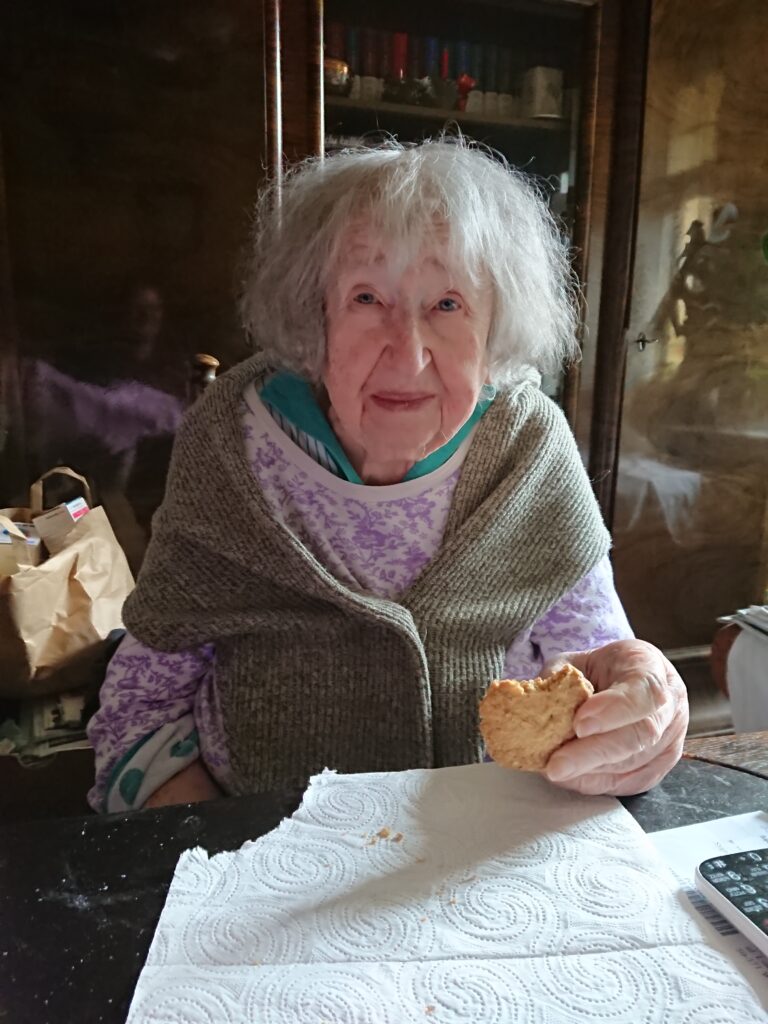 Starsza kobieta trzymająca w dłoni ciastko